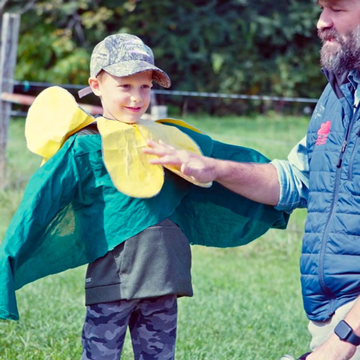 A young boy dresses up as a pea plant.